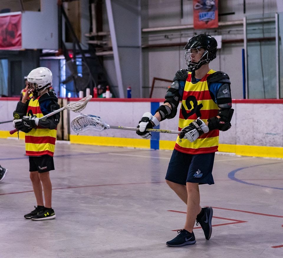 Image of children playing lacrosse and having fun.